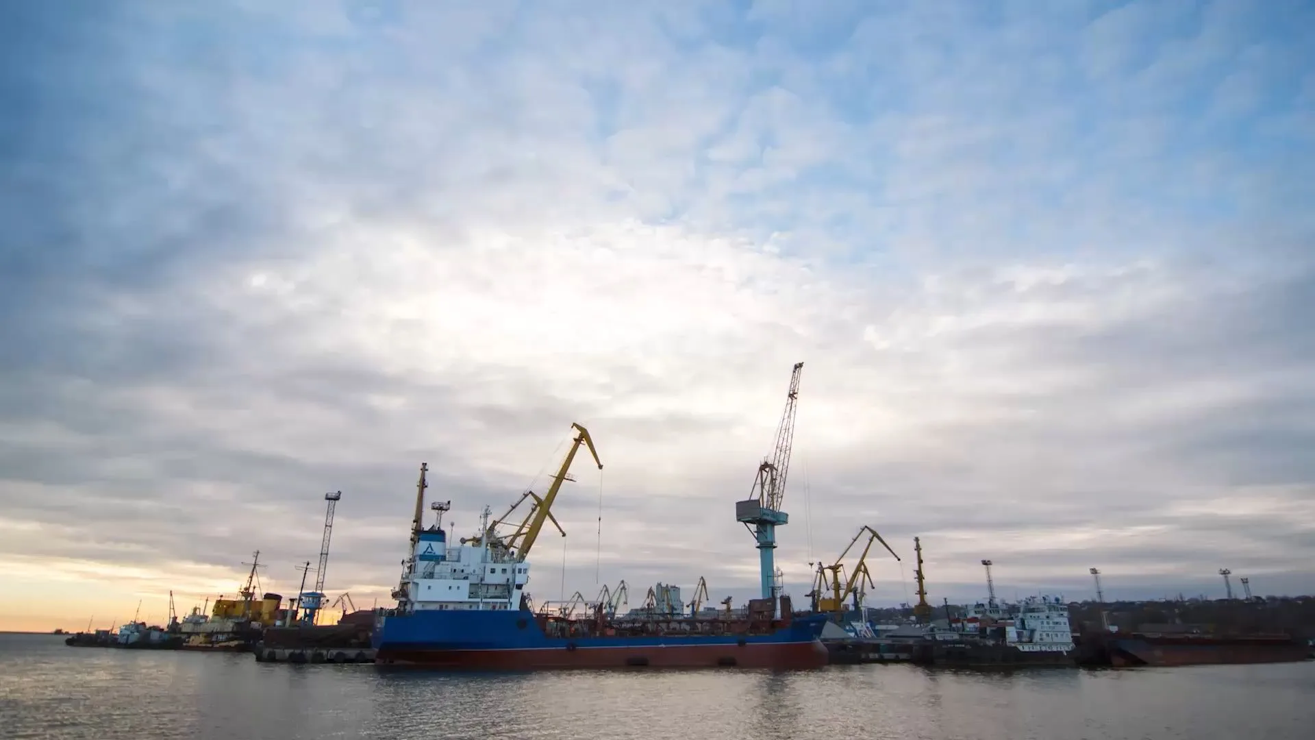 Ships and cranes in a port at dusk